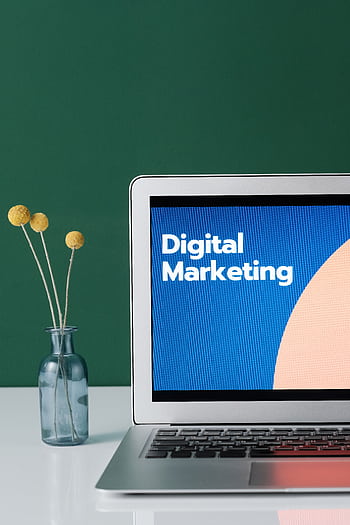 A laptop displaying 'Digital Marketing' with a minimalist floral decor in a glass vase. HD phone wallpaper