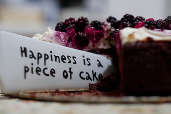 Slice of berry-topped cheesecake with a message plate saying 'Happiness is a piece of cake'. HD wallpaper