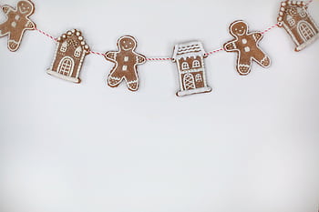 Charming gingerbread garland featuring cookies shaped as houses and gingerbread men, perfect for Christmas decor. HD wallpaper