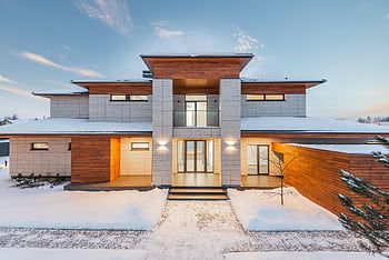 Elegant modern house with a snowy exterior and wood accents under a clear winter sky. HD wallpaper