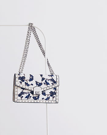 Elegant white handbag with blue floral design and silver chain, perfect for fashion enthusiasts. HD phone wallpaper
