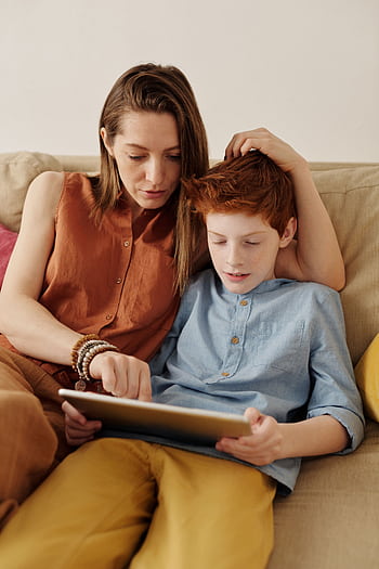 A mother and son bonding as they use a tablet together indoors. HD phone wallpaper