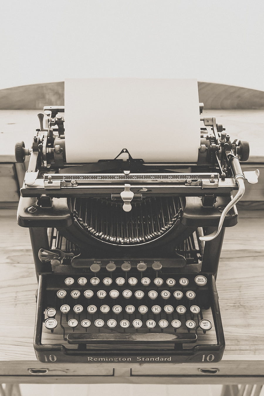 Classic Remington Standard typewriter on a wooden desk, evoking a sense of nostalgia and vintage charm. HD phone wallpaper