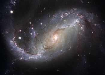 Capture of the NGC 1672 spiral galaxy showcasing its majestic spiral arms and bright core. HD wallpaper