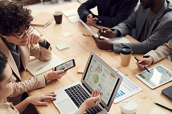 A multicultural team discussing analytics and strategy in a modern office setting. HD wallpaper