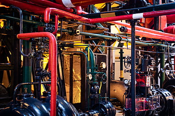 Complex network of industrial pipes and machinery inside a Lisbon plant. HD wallpaper