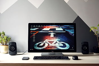 Sleek setup featuring a monitor with urban cycling , surrounded by speakers and plants. HD wallpaper