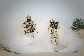 Two soldiers in full gear advancing through smoke during a military operation. HD wallpaper