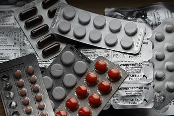 Close-up of various pills in blister packs showcasing medical and healthcare themes. HD wallpaper