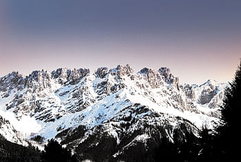 Breathtaking view of snow-covered mountains in Ellmau, Tirol capturing the serene beauty of winter. HD wallpaper