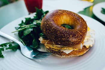Bagel close-up, Appetizing sight, Enjoyable eating, Cutlery in frame HD wallpaper