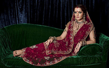 Celina Jaitley in traditional Indian clothing, tradional Indan dress, posing on couch, bindi on her forehead, brunette, colour red, jewelry HD wallpaper