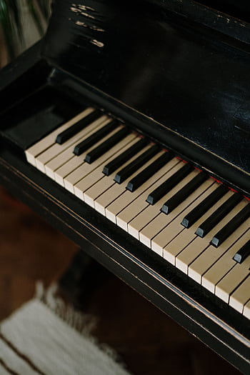 Detailed shot of vintage piano keys highlighting their classic elegance and timeless appeal. HD phone wallpaper
