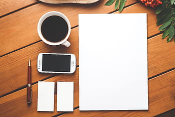 A clean and modern workspace setup with coffee, , and stationery on a wooden surface. HD wallpaper