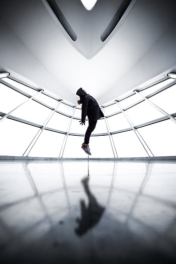 A person seemingly levitates in a contemporary room with reflections and shadows. HD phone wallpaper