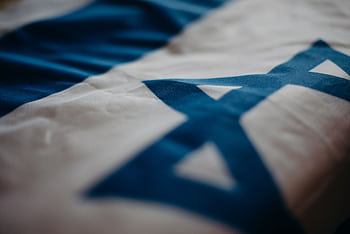 Detail of the Israeli national flag highlighting the Star of David, emphasizing its cultural significance. HD wallpaper