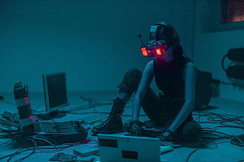 A person in a VR headset hacking in a moody, neon-lit environment. HD wallpaper