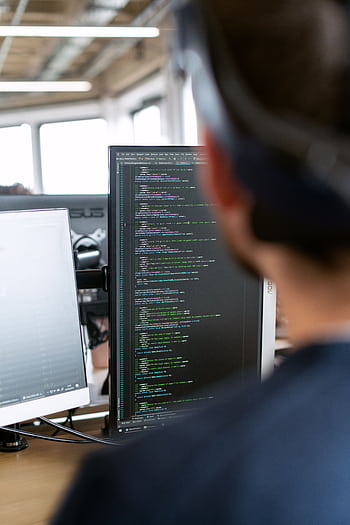 A male software engineer working on code in a modern office setting. HD phone wallpaper