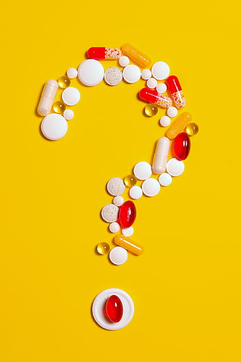 A creative arrangement of various pills forming a question mark against a bright yellow background. HD phone wallpaper