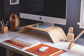 Sleek modern home office desk with computer, wooden accessories, and organized workspace. HD wallpaper