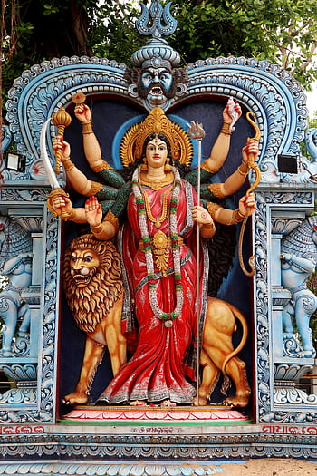 Colorful statue of a Hindu goddess with lion in Urali, India, showcasing traditional artistry. HD phone wallpaper