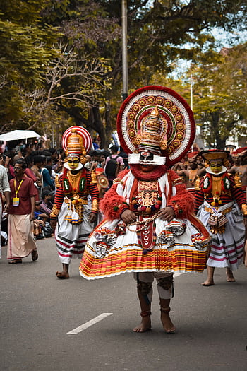 Traditional dancers in ornate costumes celebrate a cultural festival in Kerala, India. HD phone wallpaper