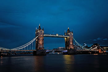A stunning view of the illuminated Tower Bridge in London against a deep blue night sky. HD wallpaper