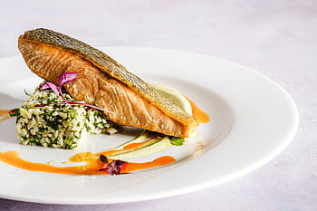 A beautifully plated salmon dish with quinoa, herbs, and a vibrant sauce, perfect for gourmet food lovers. HD wallpaper