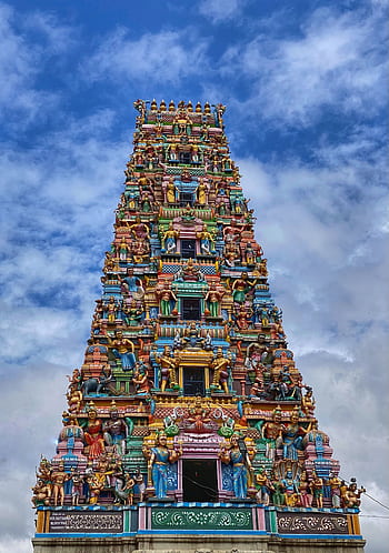 Colorful gopuram of a Hindu temple in Kodihalli, India showcasing intricate sculptures against a blue sky. HD phone wallpaper