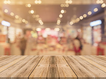 Empty wooden table with blurred shopping mall background and bokeh lights. HD wallpaper