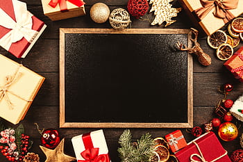 Christmas blackboard surrounded by gifts and ornaments, perfect for holiday greetings. HD wallpaper