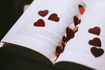 An open book adorned with red heart-shaped confetti, perfect for Valentine's or romantic themes. HD wallpaper