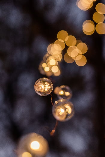 Festive string lights glowing with a soft bokeh effect, perfect for holiday or celebration themes. HD phone wallpaper