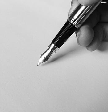 A close-up of a fountain pen writing on blank paper in black and white, capturing elegance. HD phone wallpaper