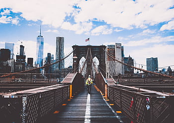 Iconic Brooklyn Bridge view with New York City skyline and construction worker. HD wallpaper