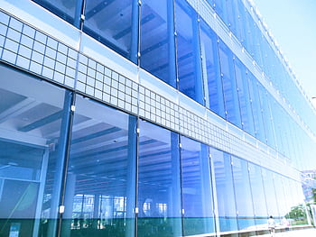 Contemporary glass building facade with reflections in the city, highlighting urban architecture. HD wallpaper