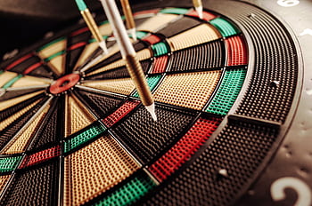 A detailed close-up of an electronic dartboard, showcasing vibrant colors and precision darts hitting the target. HD wallpaper