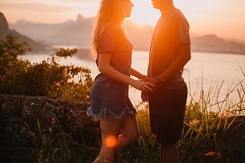 A couple enjoys a romantic sunset overlooking Rio's skyline in Jurujuba, Brazil. HD wallpaper