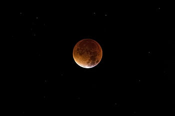 Beautiful of a lunar eclipse, showcasing the moon's dramatic red hue against a starry sky. HD wallpaper
