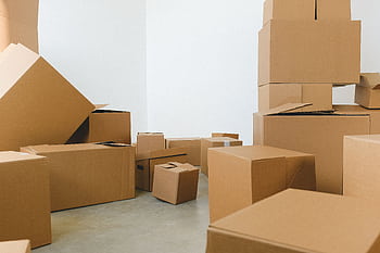 A collection of cardboard boxes scattered in an empty room, suggesting a move or relocation. HD wallpaper