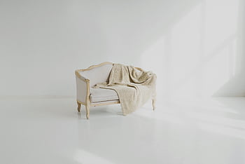 A beige throw on a vintage white sofa in a bright minimalist living space. HD wallpaper