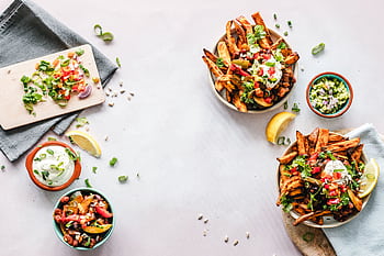 Colorful flat lay featuring sweet potato fries, guacamole, and fresh veggies, perfect for a healthy meal. HD wallpaper
