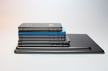 Stacked modern smarts and tablets showcasing sleek design. Perfect tech background. HD wallpaper