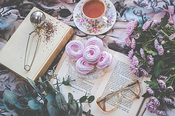 Delicate flatlay with pink pastries, tea, flowers, book, and glasses for a romantic setting. HD wallpaper