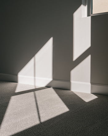 Modern interior with sunlight casting geometric shadows through windows. HD phone wallpaper