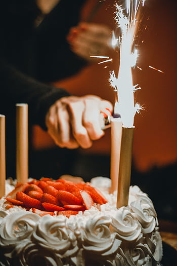 A captivating of a birtay cake adorned with lit sparklers and fresh strawberries. HD phone wallpaper