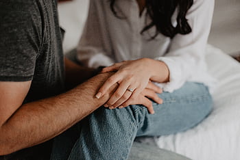A tender moment of a couple holding hands, symbolizing love and connection. HD wallpaper