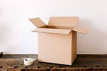 An open cardboard box alongside tape and scissors on a wooden table, ready for packing or moving. HD wallpaper