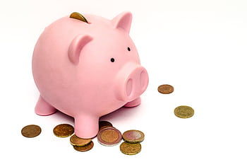 A pink piggy bank surrounded by scattered coins, symbolizing savings and financial investment. HD wallpaper