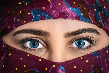 Close-up portrait of a woman with striking eyes and a colorful patterned headscarf. HD wallpaper